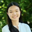 Lily, a young Chinese woman, smiles. Her hair is down and she wears a white shirt.